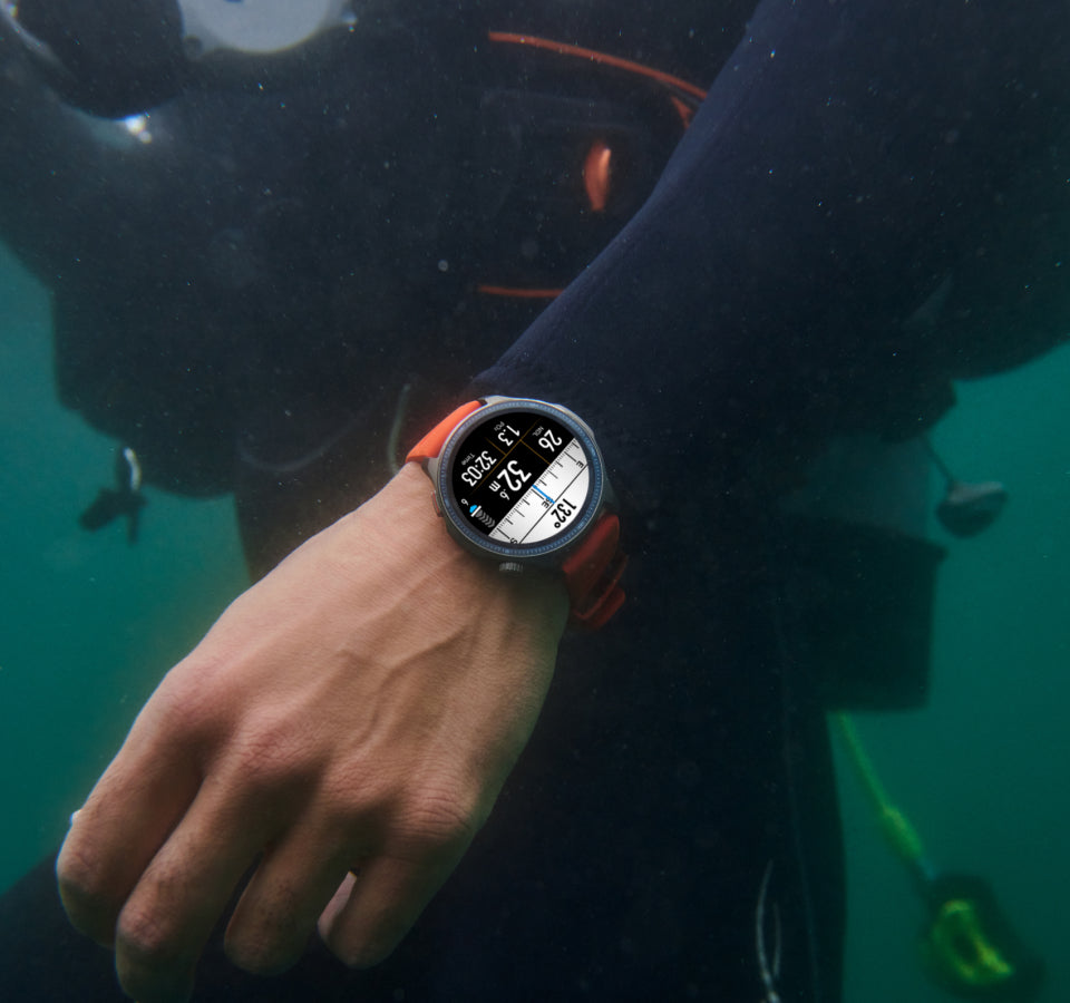 Person underwater wearing a smartwatch with diving computer display